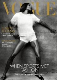 Gabby Thomas in a white fringed top and shorts leaning against a textured grey wall for American Vogue Winter 2025