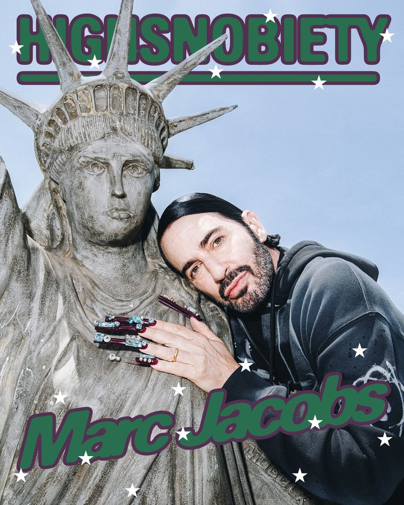 Marc Jacobs leans against Statue of Liberty, posing with long decorative nails. The image features text overlay and cartoon star graphics.