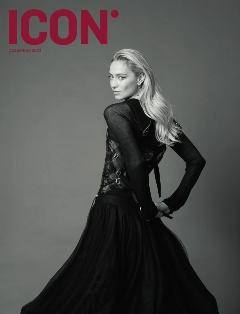Magazine cover featuring a blonde adult female in a long black dress, posing against a neutral gray background, showcasing fashion editorial style.