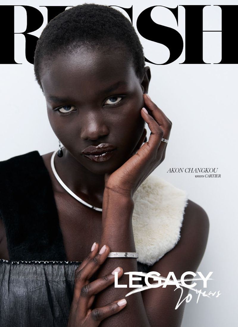 Magazine cover featuring a dark-skinned woman with a serious expression, wearing a white collar, and posing with her hand to her face.