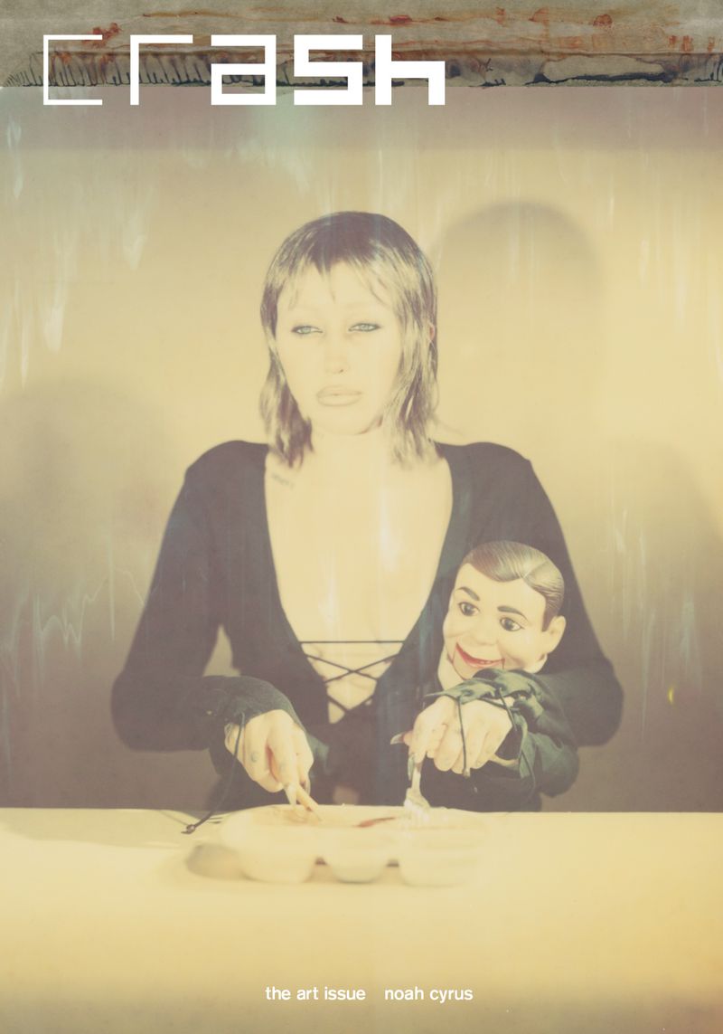 CRASH magazine cover featuring a woman holding a dummy, holding knives above food on a table, in a photo studio setting.