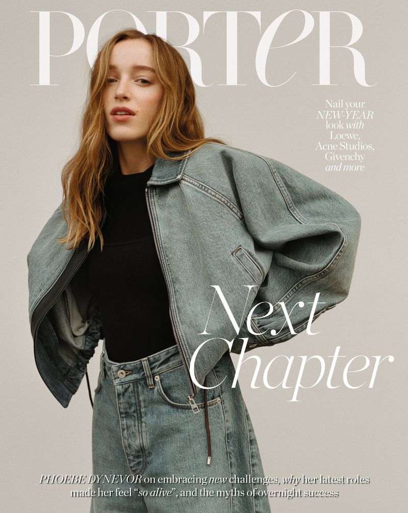 Phoebe Dynevor poses on the Porter magazine cover wearing a denim jacket and jeans in a studio shot. Fashion editorial style.