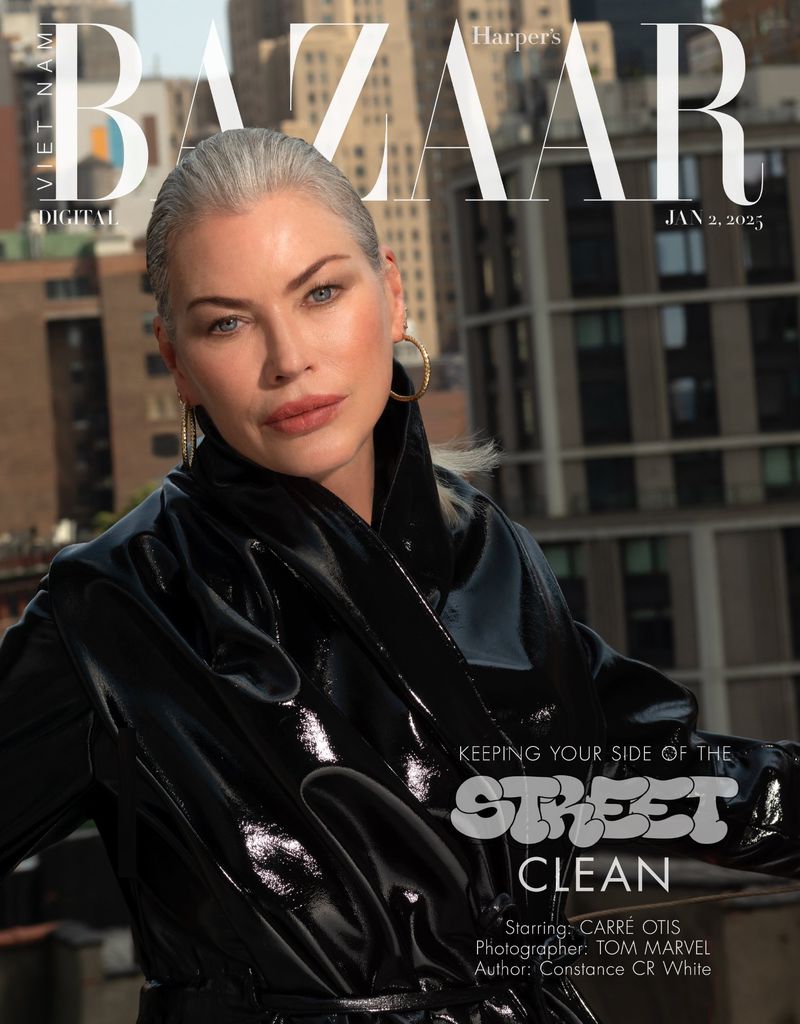 Editorial fashion photography: Silver-haired woman in shiny black coat against urban backdrop for Harper's Bazaar cover, Jan 2, 2023.