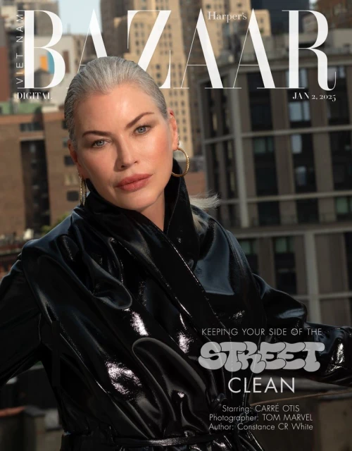Editorial fashion photography: Silver-haired woman in shiny black coat against urban backdrop for Harper's Bazaar cover, Jan 2, 2023.