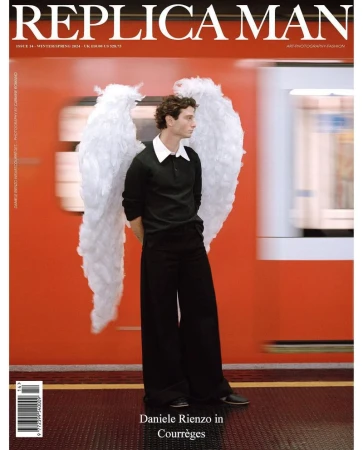 Magazine cover featuring a slender man with wings standing in a train station wearing a black outfit against a red train backdrop.