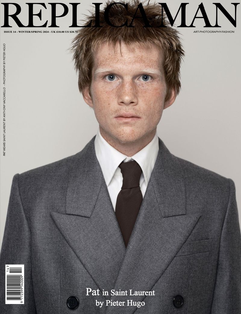 Replica Man magazine cover featuring a red-haired male model with freckles in a grey double-breasted suit, white shirt, and brown tie on a grey background.
