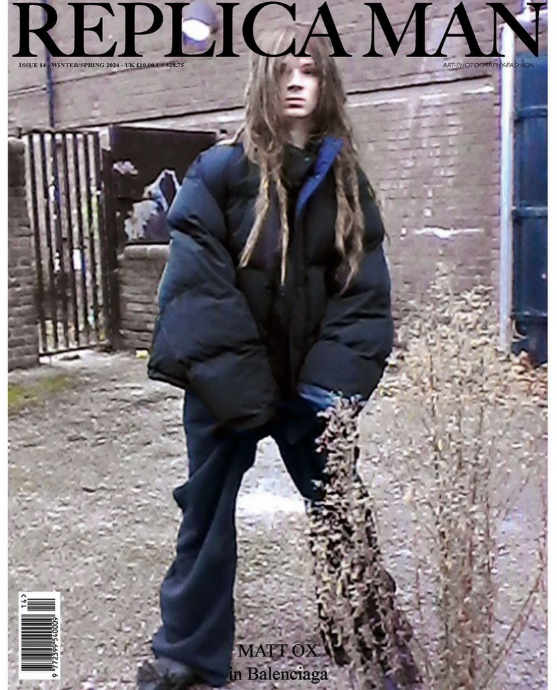 Replica Man magazine cover featuring a model wearing an oversized puffer jacket, standing outdoors with neutral color grading.