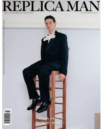 Magazine cover featuring a man in a black suit and white bow sitting atop a wooden ladder against a light wall.