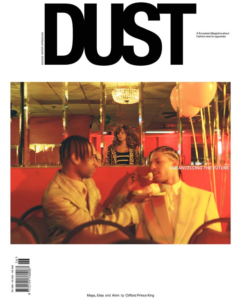 Magazine cover featuring two people dining; the 'Dust' logo and 'Uncancelling the Future' headline displayed, set in a red interior.