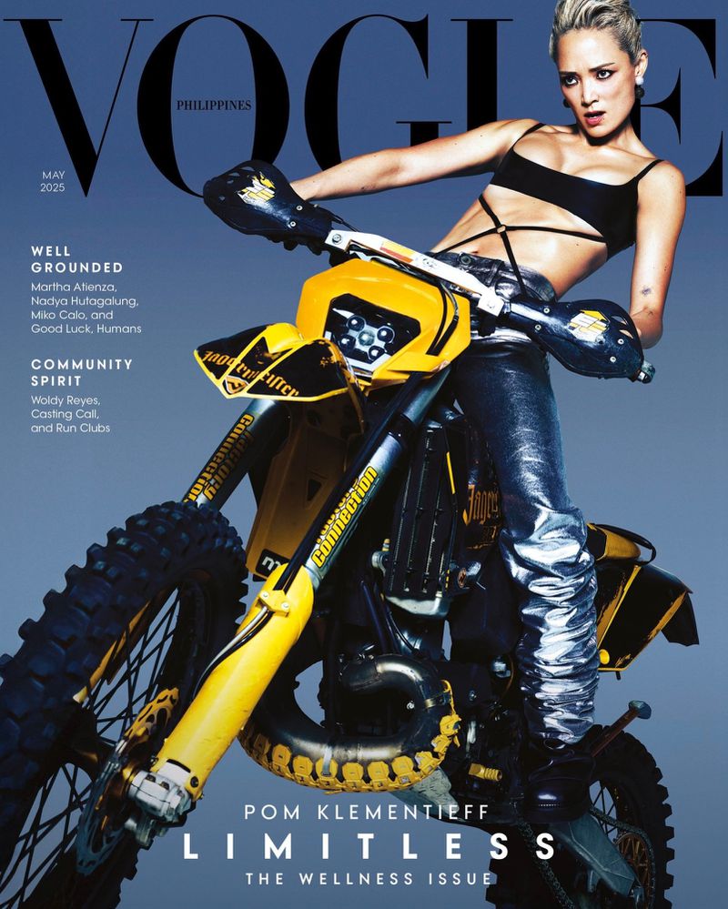 Vogue Philippines magazine cover featuring Pom Klementieff on a yellow and black motorcycle, May 2023 wellness issue, blue background.