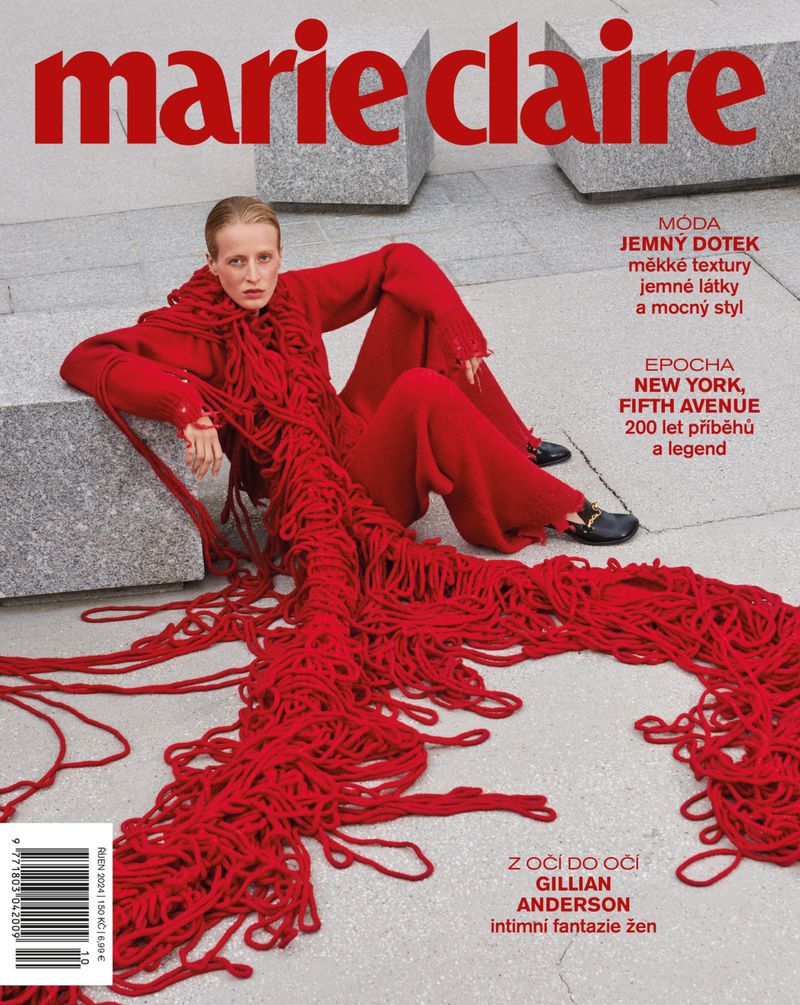 Marie Claire cover featuring a fashion model in red outfit with long fringe, sitting on a stone structure in an outdoor setting.