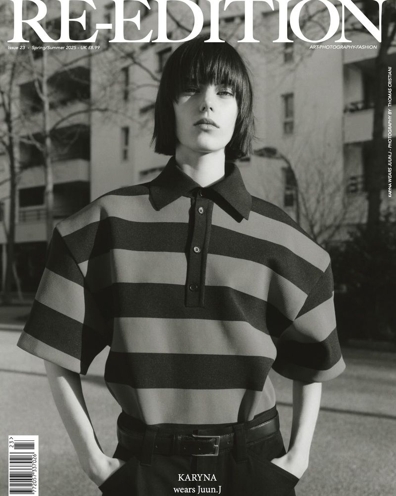 Monochrome magazine cover featuring a model with short dark hair in a striped polo shirt against residential buildings