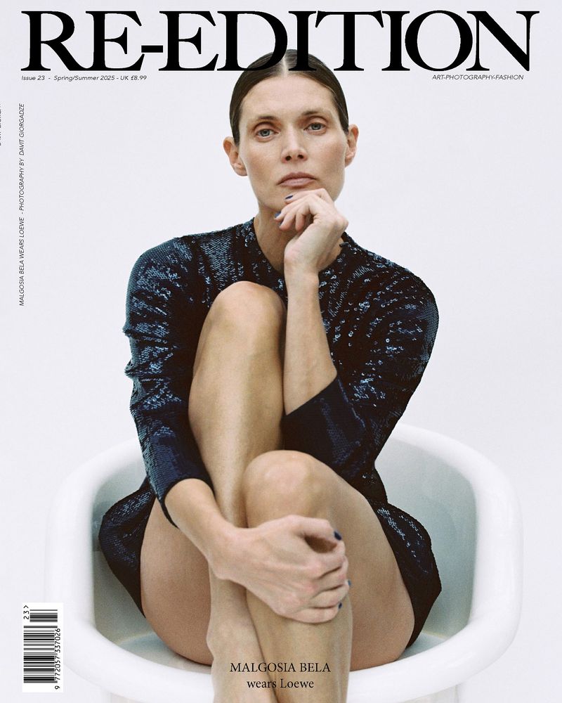 Magazine cover featuring a woman in a sequined dress sitting in a white tub, looking at the camera with a neutral expression.