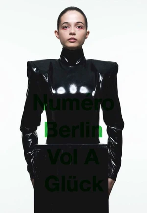 Model in black latex high-neck top against white seamless background with green overlaid text