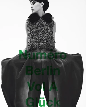 Model in textured sleeveless top and wide skirt posing against white backdrop for Numero Berlin