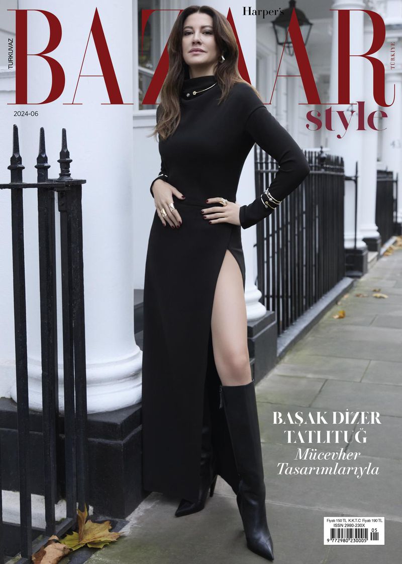 Magazine cover featuring a woman in a black dress with a thigh-high slit, accessorized with jewelry and black boots, against an outdoor setting.