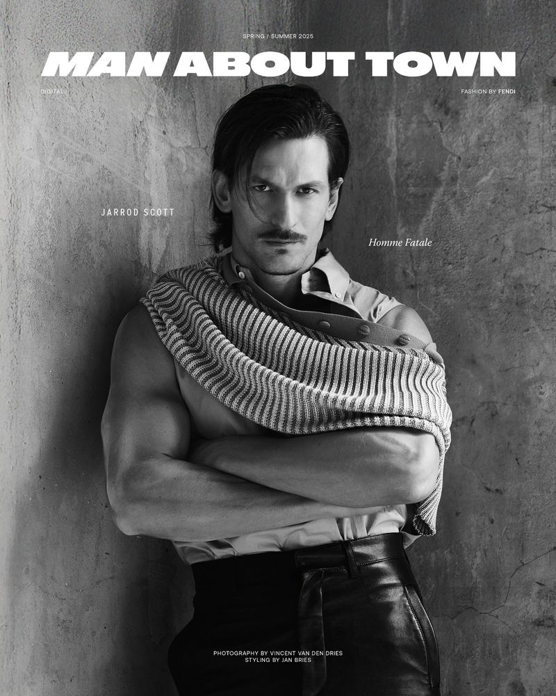 Black and white magazine cover featuring a muscular man with a mustache wearing black pants and an unbuttoned shirt with a striped cloth.