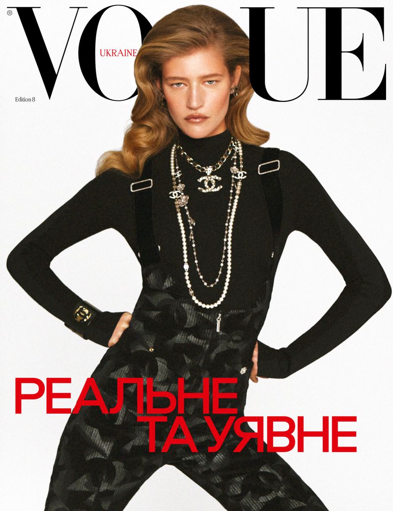 Vogue Ukraine cover featuring a blond-haired fashion model wearing a black top and patterned pants, accessorized with layered necklaces.