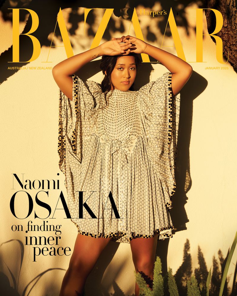 Naomi Osaka on the cover of Harper's Bazaar Australia, wearing a printed dress, posing with hands above her head in a close-up shot.