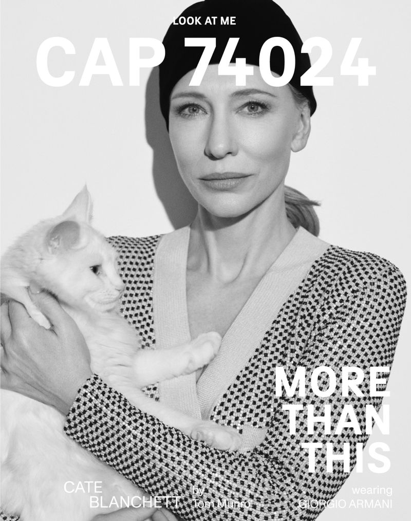 Black and white portrait of Cate Blanchett in patterned cardigan holding a white cat, studio background, soft lighting, elegant style.