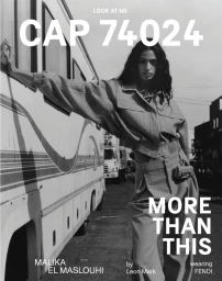 Model Malika El Maslouhi leaning against a recreational vehicle wearing belted trousers and jacket, captured in monochrome.