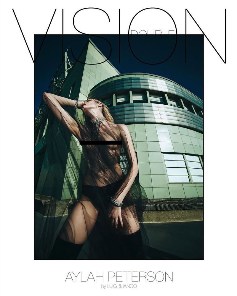 Model in sheer black fabric posing against a green architectural building for Double Vision Holiday 2024 covers by Luigi & Iango