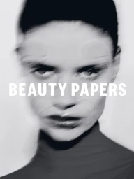 Close-up portrait of a model with motion blur and overlay text reading BEAUTY PAPERS against a white background