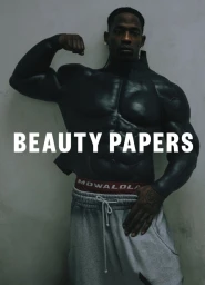 Travis Scott flexing with painted black torso wearing grey sweatpants for Beauty Papers cover.