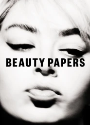 Black and white close-up portrait of a woman with bold winged eyeliner and the text BEAUTY PAPERS printed across her face.