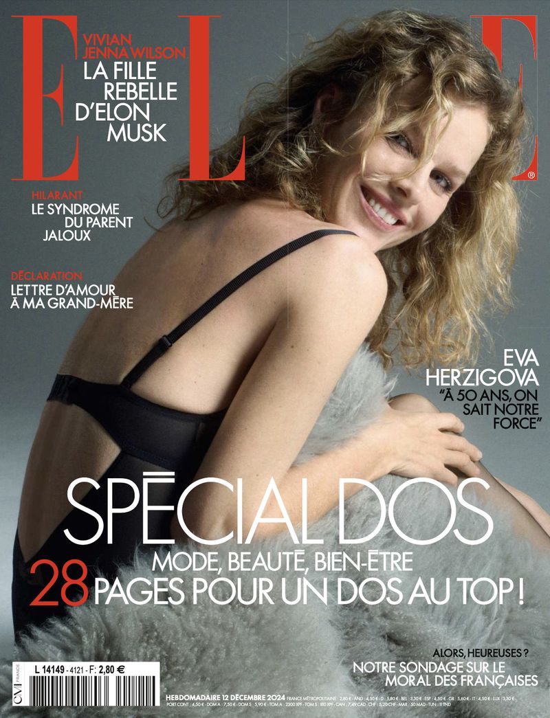 Elle magazine cover featuring a smiling woman in black lingerie and blonde curly hair, accessorized with a gray fur wrap. 