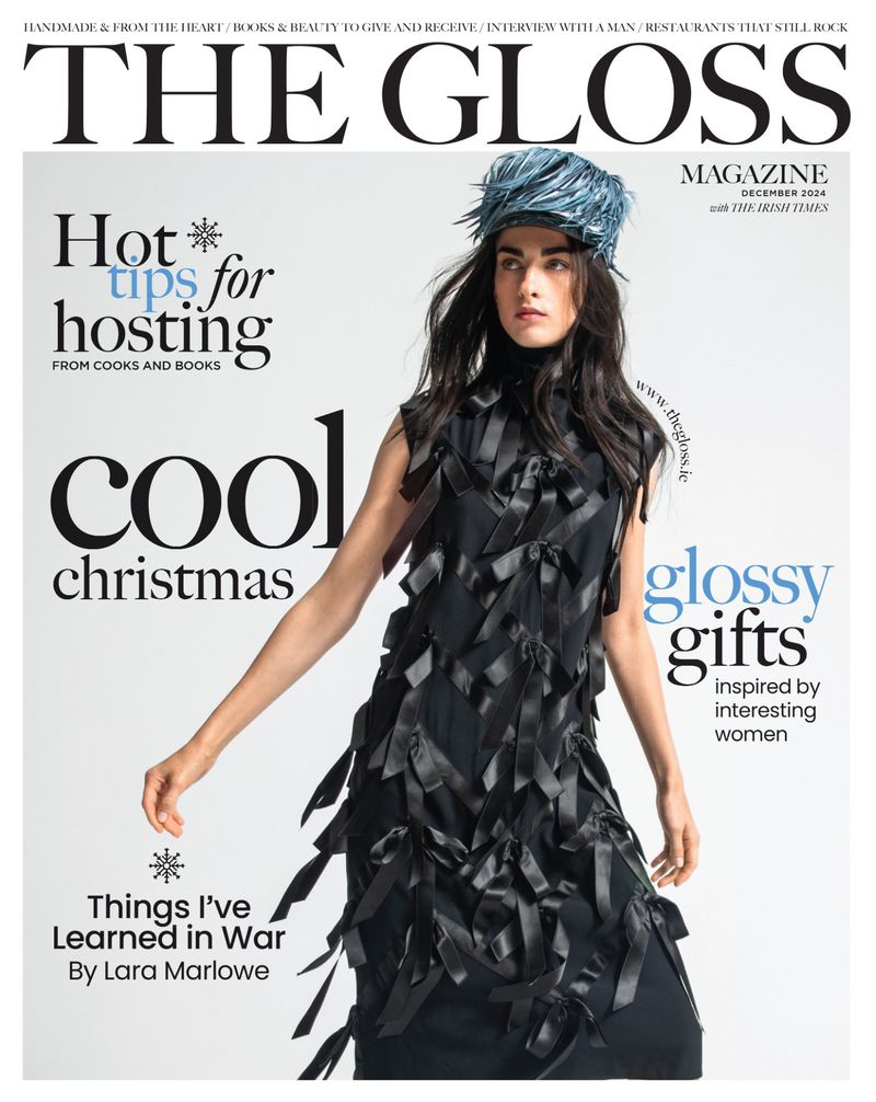 Magazine cover featuring a woman in a black dress and blue feather hat, promoting holiday tips, Christmas, and glossy gifts.