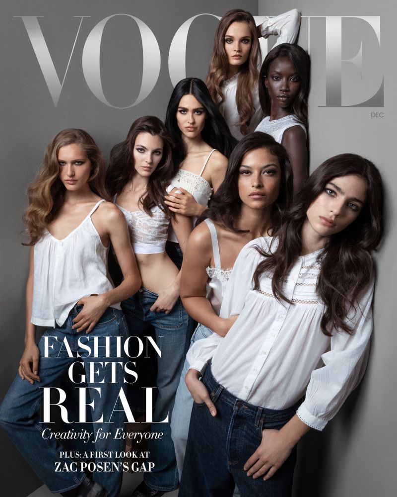 Fashion magazine cover featuring a group of diverse female models wearing white tops and blue jeans, posing together in a studio.