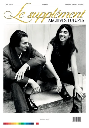 Black and white fashion magazine cover featuring a smiling couple in jackets and boots, leaning against concrete steps with magazine text overlay.