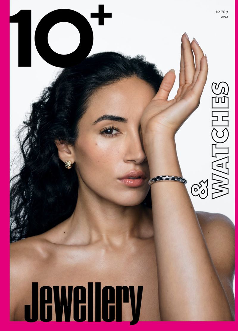 Beauty portrait of a woman with dark wavy hair wearing a patterned cuff bracelet and gold earring on a magazine cover.