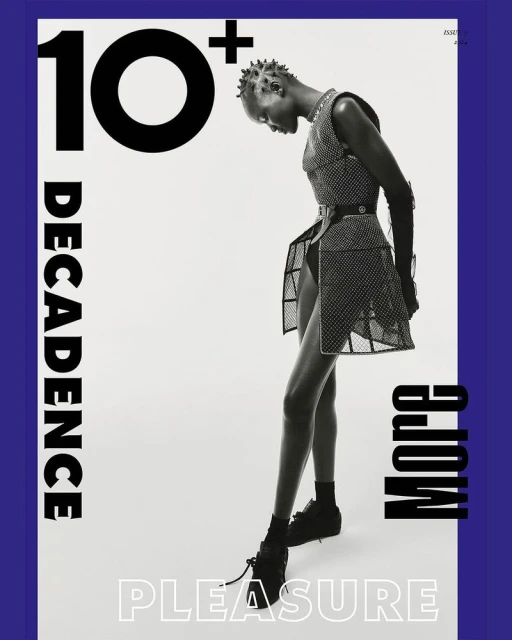 Black female model poses in a translucent black mesh dress with black boots against a white background in a fashion editorial shot.