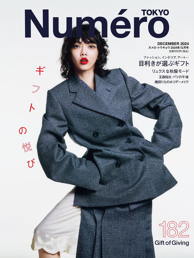 Magazine cover featuring a woman in a grey blazer and skirt against a white background with magazine text overlay.