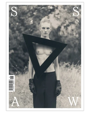 Monochromatic magazine cover featuring a shirtless male model with a triangle prop, set against a blurred natural background.