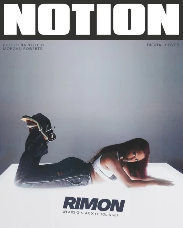 Fashion magazine cover featuring a woman in jeans and a white top lying on a glowing surface with bold text overlays.