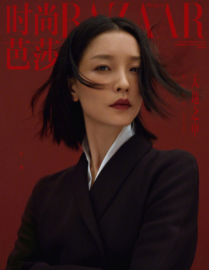 Close-up portrait of an Asian woman with dark hair wearing a black blazer, set against a deep red backdrop with magazine text.