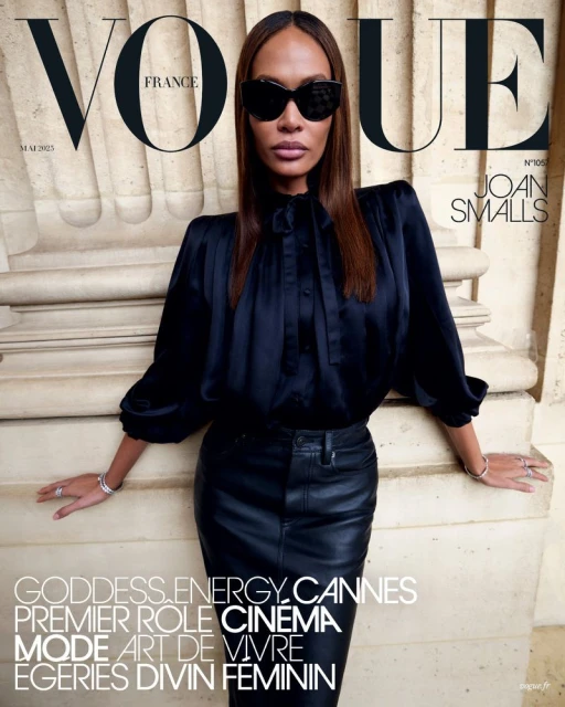 Vogue France cover featuring Joan Smalls in a black blouse and leather skirt, accessorized with bracelets and sunglasses, posing outdoors.