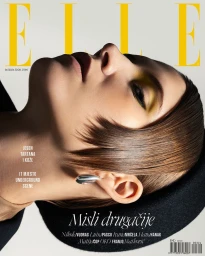 Close-up profile portrait of a model with short brown hair and yellow eye makeup against a white background for Elle Croatia.