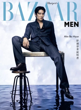 Magazine cover featuring a seated Asian man in a denim suit with dark hair, wearing dark shoes, set against a water and sky backdrop.