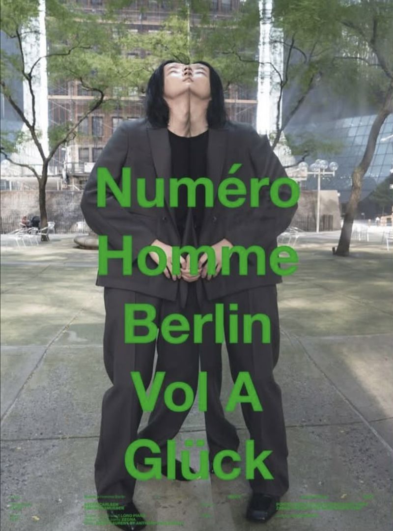 Artistic fashion magazine cover featuring a digitally manipulated male figure in a suit against an urban backdrop in cool tones.