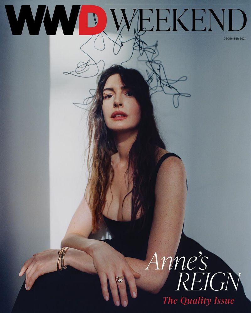 Anne Hathaway in black dress on WWD Weekend cover with wire art behind her head, captured in medium shot with indoor setting.