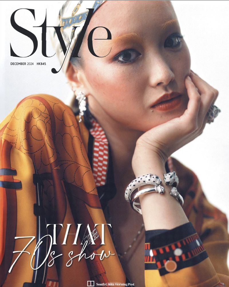 Magazine cover featuring a woman with a patterned headscarf and jacket, showcasing 70s-inspired makeup and jewelry in a close-up shot.