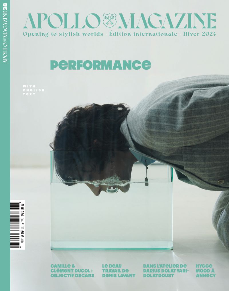 Magazine cover featuring a man in a suit with his head submerged in a clear fish tank with text overlays, set against a white backdrop.