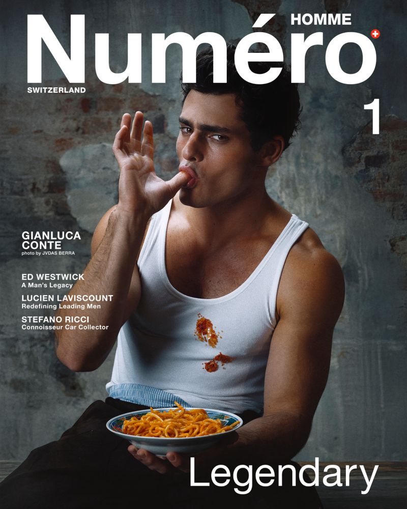 Magazine cover featuring a man in a white tank top eating spaghetti, with the 'Numéro Homme Switzerland' masthead and bold 'Legendary' text.