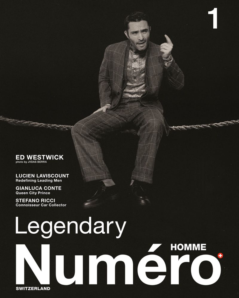 Ed Westwick poses in a grey plaid suit, seated on a rope for Numéro Homme magazine cover. A black backdrop provides contrast.