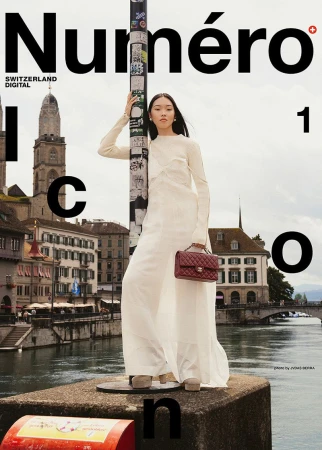 Magazine cover featuring a full-length shot of an Asian woman in a white outfit holding a dark red handbag, standing outdoors in Zurich.