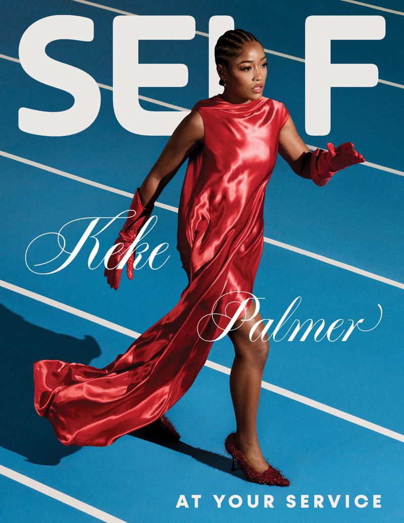 Keke Palmer in a red dress walking on a blue running track, cover for Self magazine. Bright, colorful fashion photography.